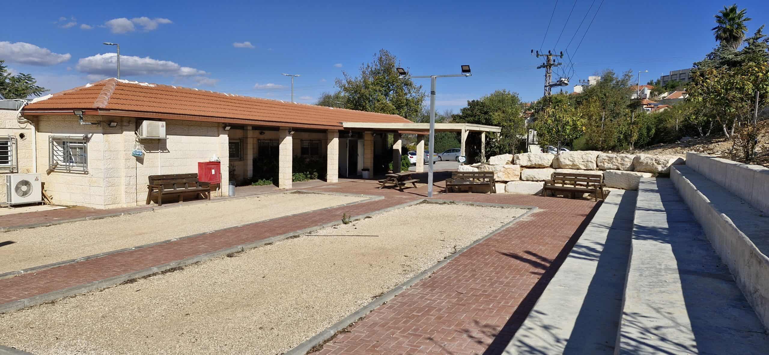 1. Modern community center in Efrat with benches, pathways, and landscaped surroundings.