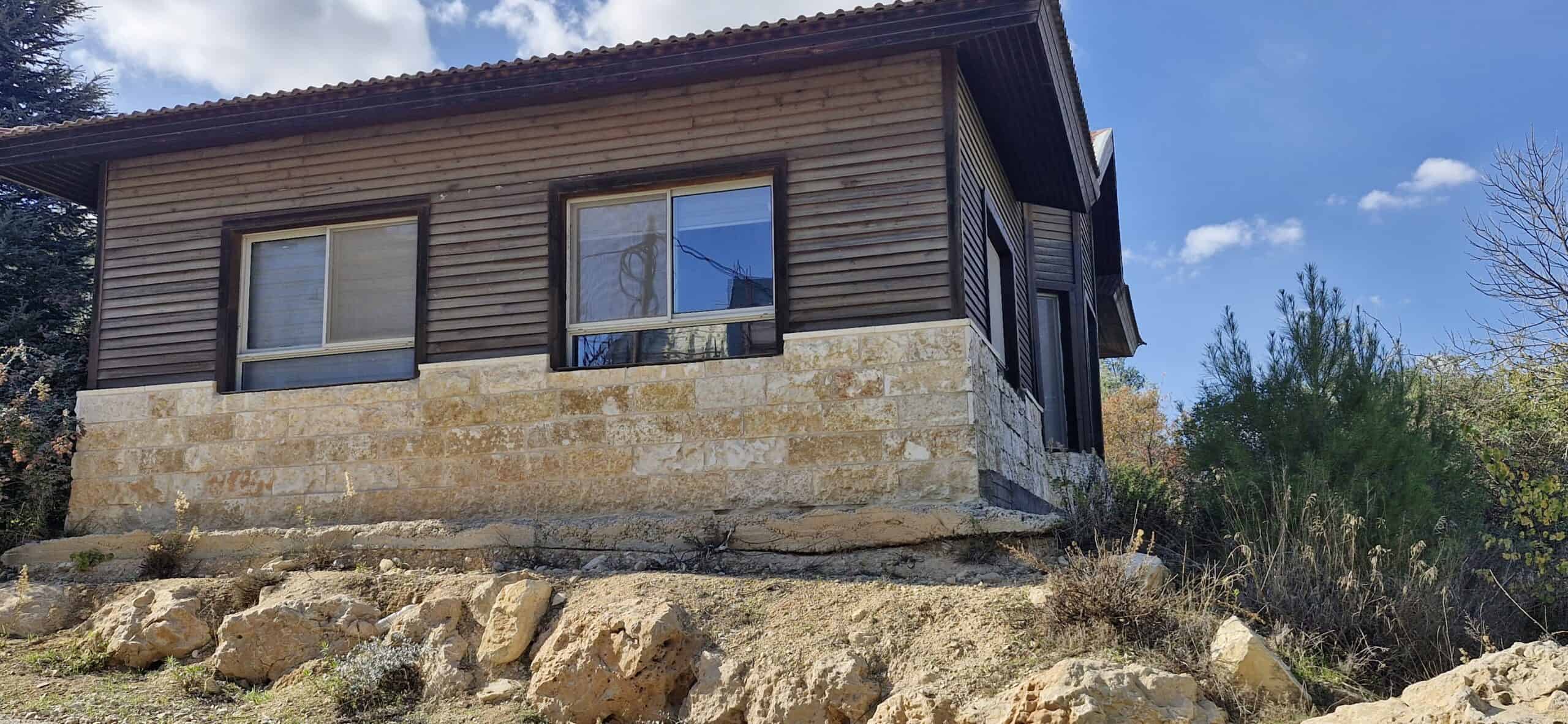 Bright wooden house built with natural stone foundation in Efrat, Israel, promoting sustainable community development.